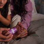 Parent applying doTERRA Lavender Peace Stick to a child’s foot