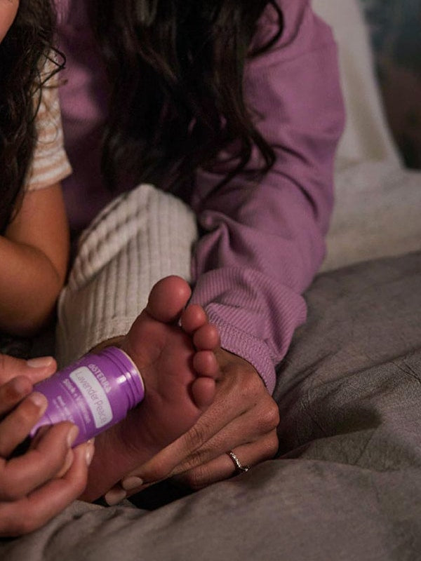 Parent applying doTERRA Lavender Peace Stick to a child’s foot