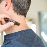 Man applying doTERRA PastTense Roll-On to his neck