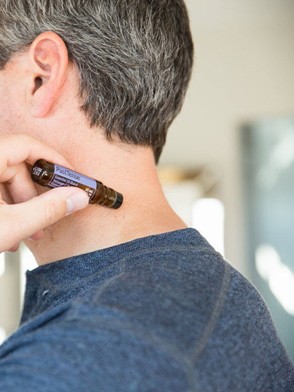 Man applying doTERRA PastTense Roll-On to his neck