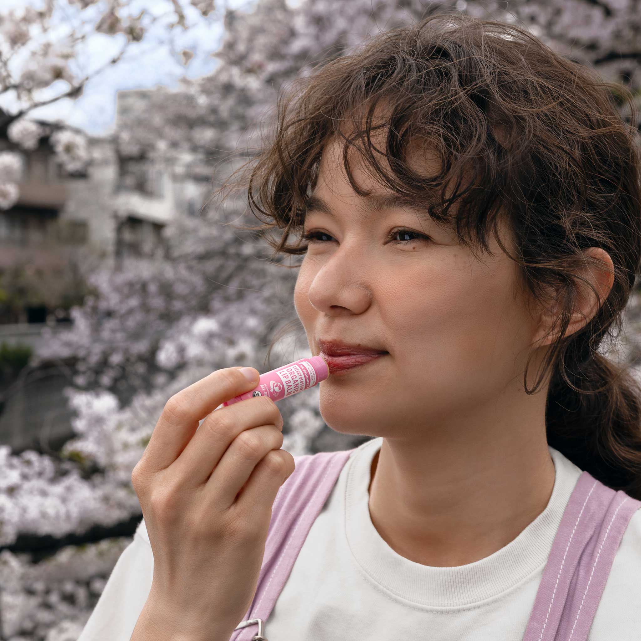 Person applying Dr. Bronner's Cherry Blossom Organic Lip Balm