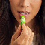 Person applying Dr. Bronner's Lemon Lime Organic Lip Balm