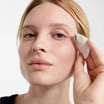 Model removing eye makeup with a cotton pad after using Dr Hauschka Eye Make-up Remover 75ml.