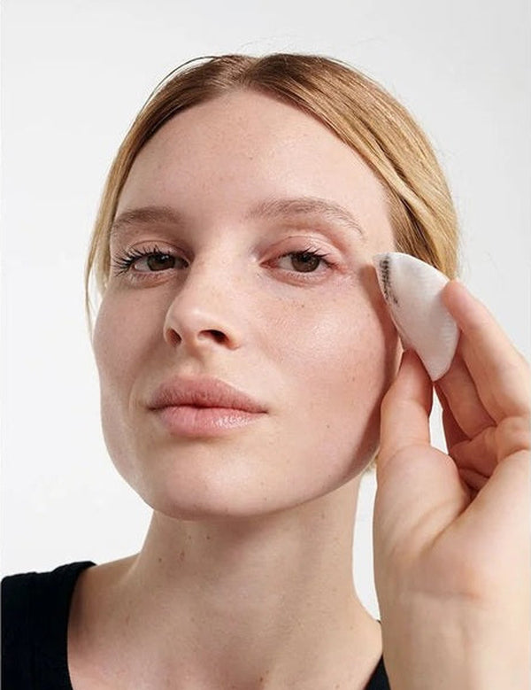 Model removing eye makeup with a cotton pad after using Dr Hauschka Eye Make-up Remover 75ml.