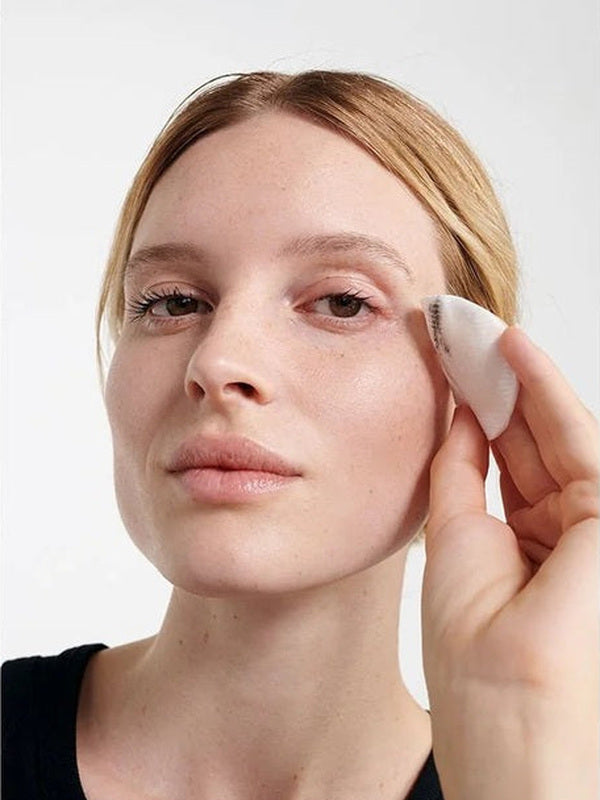 Model removing eye makeup with a cotton pad after using Dr Hauschka Eye Make-up Remover 75ml.