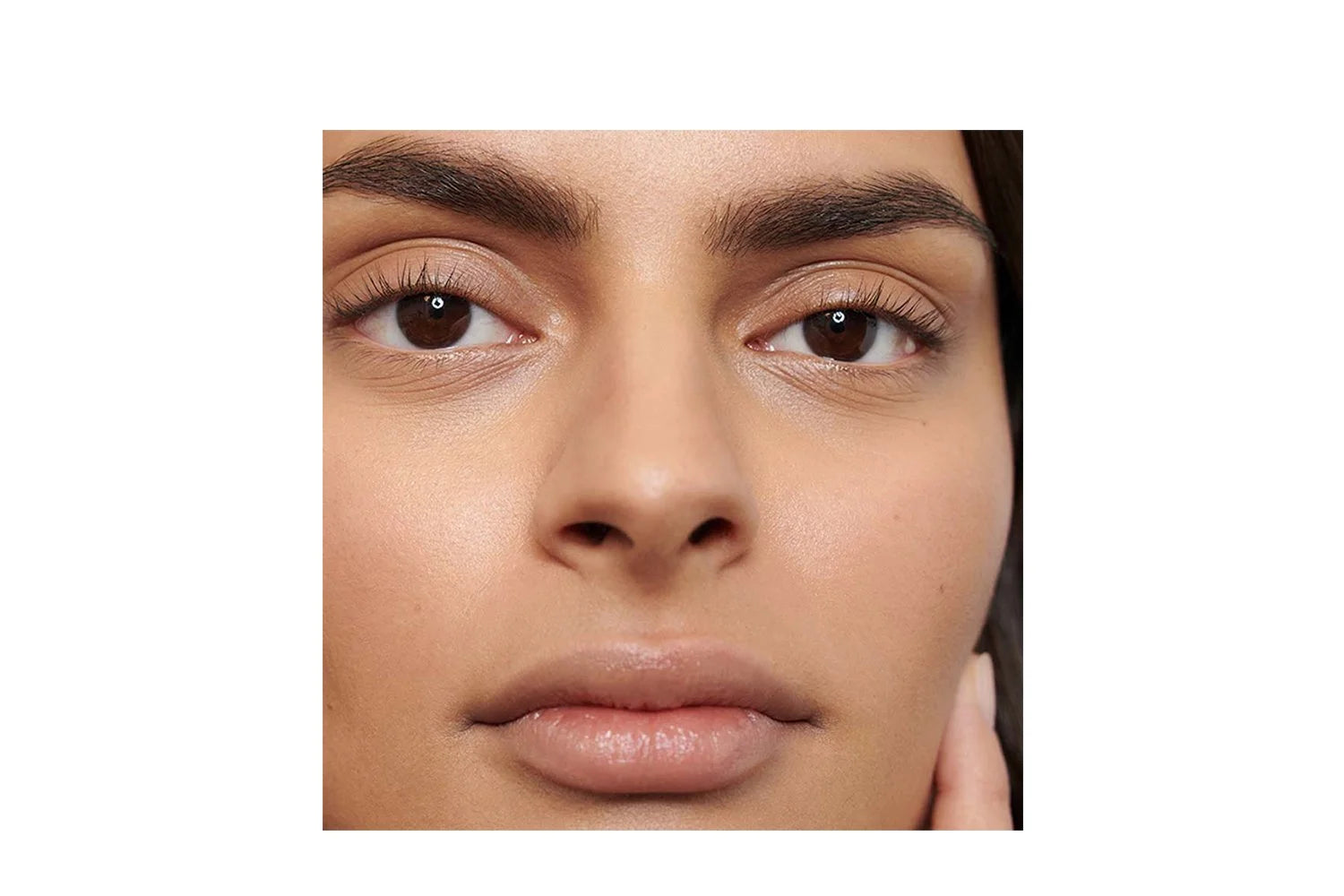 Close-up of a woman's brown eyes framed by dark, full, defined eyebrows, showing the finish of Dr Hauschka Eyebrow Definer.