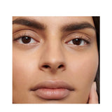 Close-up of a woman's brown eyes framed by dark, full, defined eyebrows, showing the finish of Dr Hauschka Eyebrow Definer.