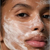 Close-up of a woman wearing Dr Hauschka Hydrating Cream Mask 30ml in visible white brush strokes across her forehead, cheeks, nose and chin.