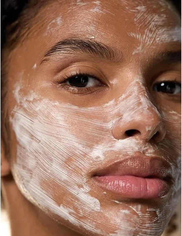 Close-up of a woman wearing Dr Hauschka Hydrating Cream Mask 30ml in visible white brush strokes across her forehead, cheeks, nose and chin.