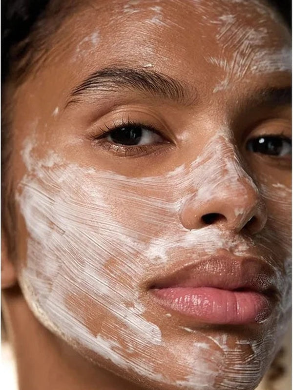 Close-up of a woman wearing Dr Hauschka Hydrating Cream Mask 30ml in visible white brush strokes across her forehead, cheeks, nose and chin.