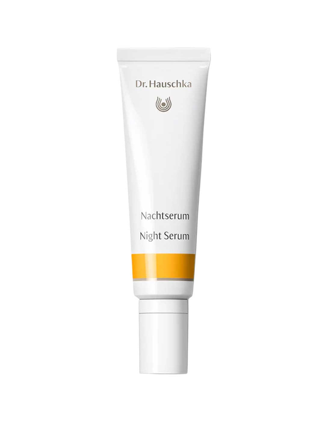 Dr Hauschka Night Serum in a slender white squeeze tube with a long white cap, grey lettering and a golden-yellow band near the base.