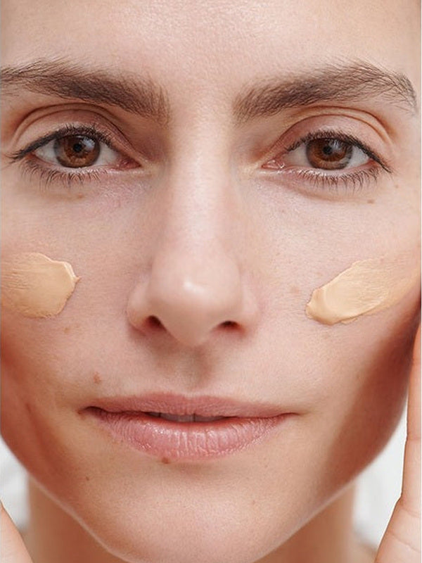 Model wearing two cheek swatches of Dr Hauschka Regenerating Day Cream Complexion Tinted 40ml before blending.