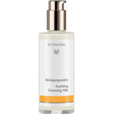Dr Hauschka Soothing Cleansing Milk in a clear bottle containing ivory lotion, with a reflective metal pump and white label with a golden-yellow band.