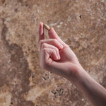 Hand holding a single Herbs of Gold Clear Skin tablet