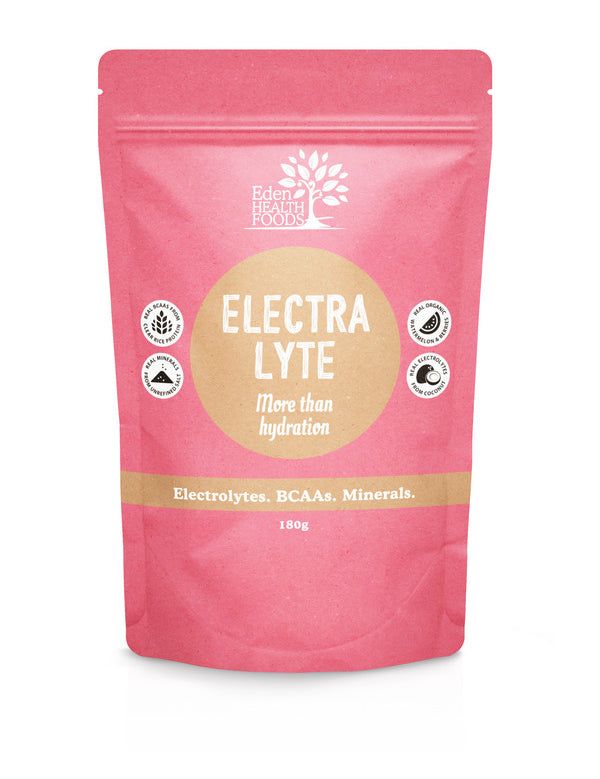 Coral-pink Eden Healthfoods Electra-Lyte Watermelon and Berry pouch standing upright, with a tan circular title panel, white lettering and four small black-and-white symbols.