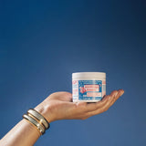 Egyptian Magic cream jar held against a blue sky