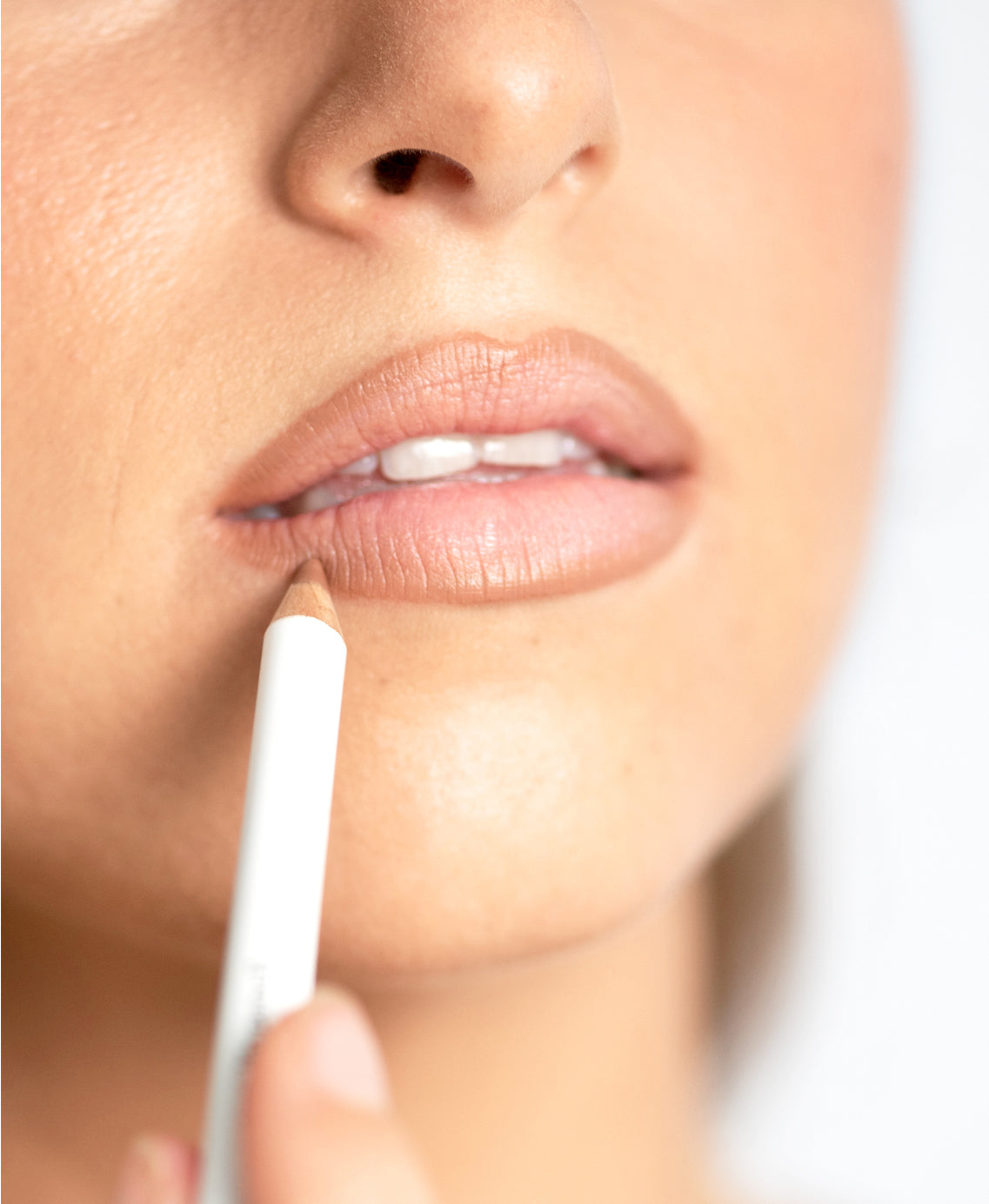 Model applying Ere Perez Acai Lip Pencil for a softly defined natural lip