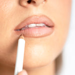 Close-up of a model applying an Ere Perez Acai Lip Pencil to the lower lip for softly defined natural colour.