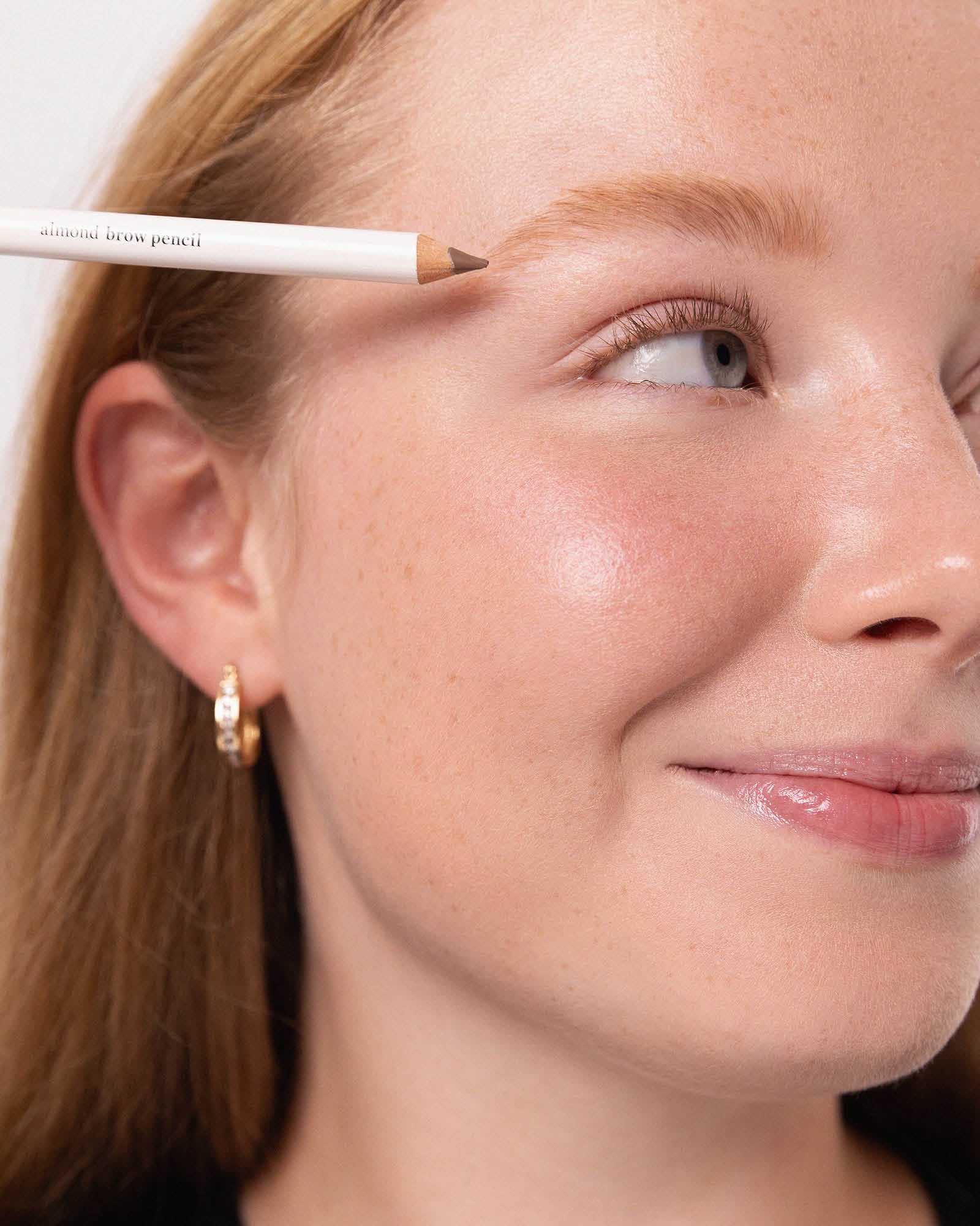Model applying Ere Perez Almond Brow Pencil