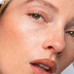 Close-up of a model applying Ere Perez Argan Brow Hero to shape and groom the eyebrow.