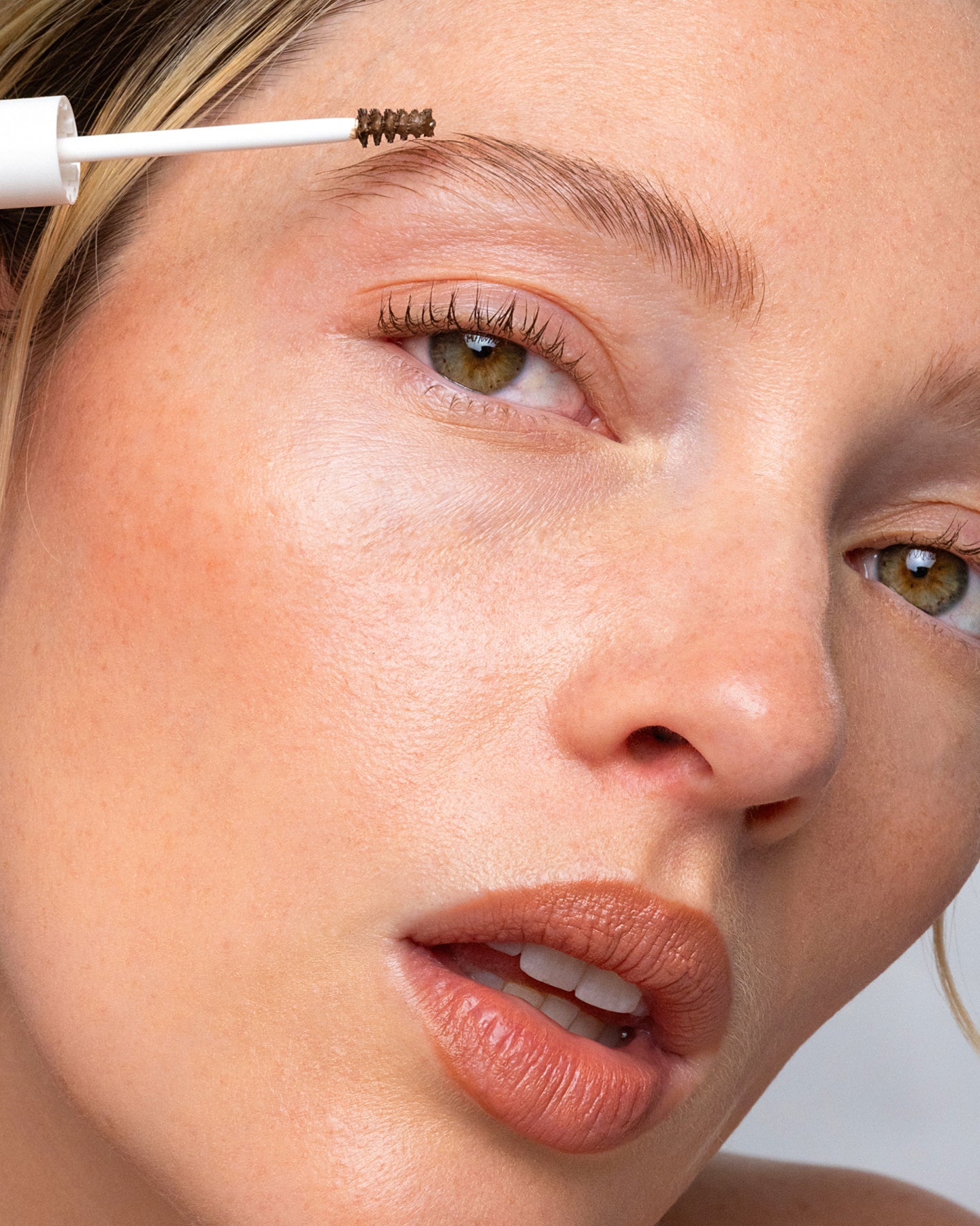 Model applying Ere Perez Argan Brow Hero to create naturally groomed brows