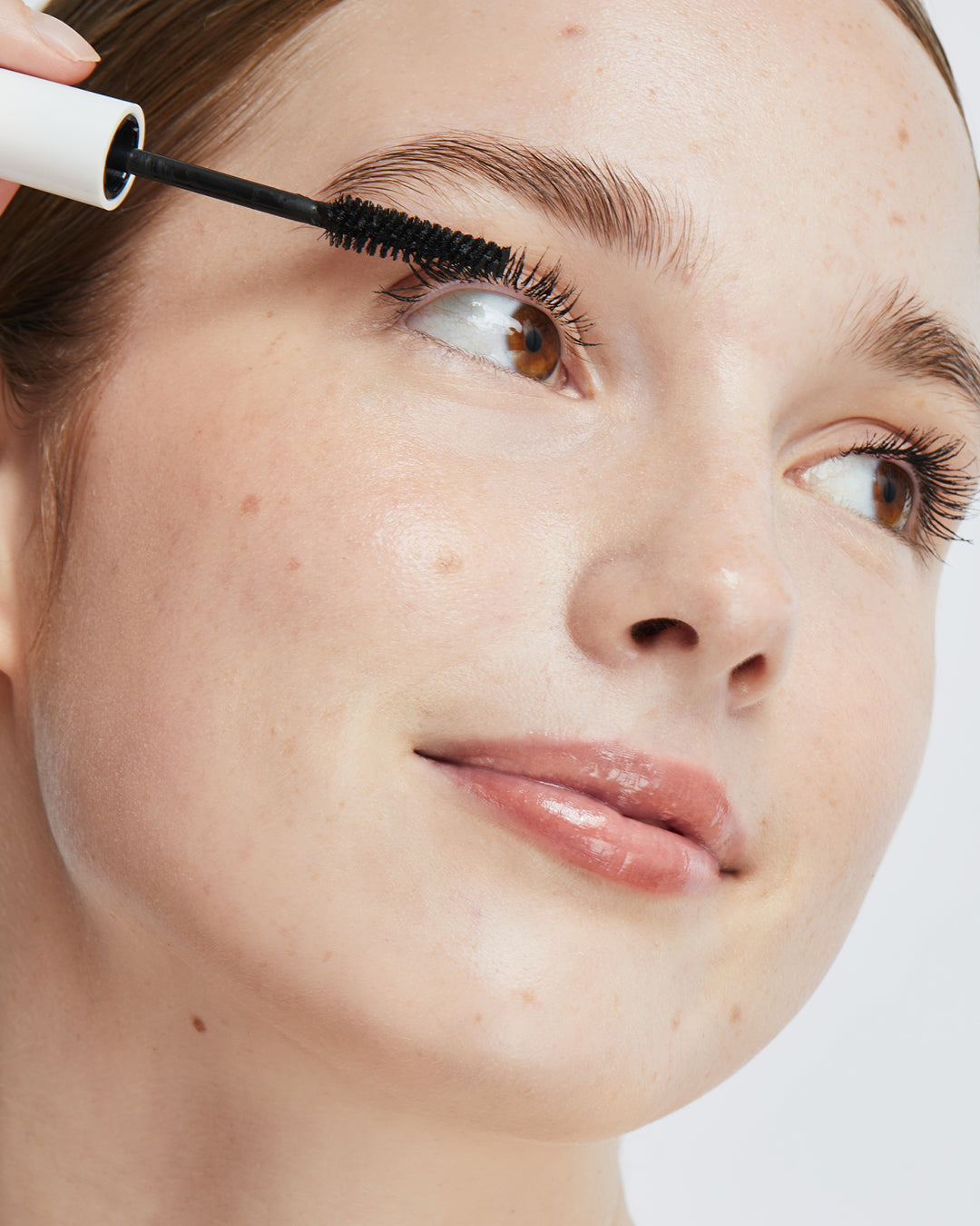 Model applying Ere Perez Avocado Waterproof Mascara