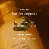 Ere Perez Black Tea Face Toner ingredient graphic over amber tea and botanicals, highlighting black tea for barrier support, grape seed extract for radiance and parsley extract for skin resilience.