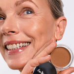 Model wearing Ere Perez Cacao Bronzing Pot in Playa and holding the open pot