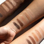 Ere Perez Element Matte eyeshadow swatches across three forearms with light, medium and deep skin tones. The five matte shades are labelled Dusk, Sand, Ochre, Oak and Terra.