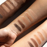 Ere Perez Element Matte eyeshadow swatches across three forearms with light, medium and deep skin tones. The five matte shades are labelled Dusk, Sand, Ochre, Oak and Terra.