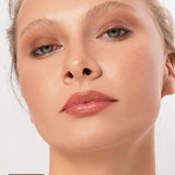 Close-up of a model wearing the earthy brown Oak shade from the Ere Perez Element Matte palette, blended over the eyelids and beneath the lower lashes. An Oak swatch appears at the lower left.
