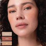 Curly-haired model wearing warm peach and bronze shimmer on the eyelids. Swatches identify Twilight, Ember, Ray and Lustre from the Ere Perez Light Shimmer palette.