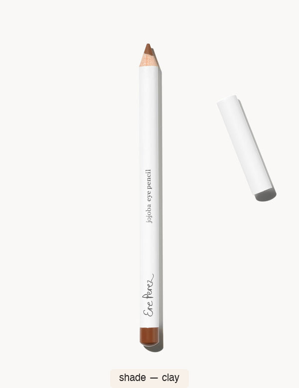 White Ere Perez Jojoba Eye Pencil in Clay, with an exposed warm brown tip, a matching terracotta-brown end cap and its white lid beside it; the shade name appears below.