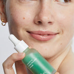 Ere Perez Native Glow Duo – quandong serum held beside a model's face