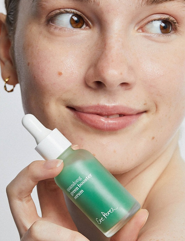 Ere Perez Native Glow Duo – quandong serum held beside a model's face