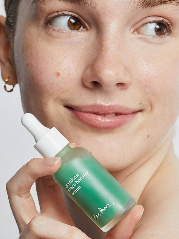 Ere Perez Native Glow Duo – quandong serum held beside a model's face