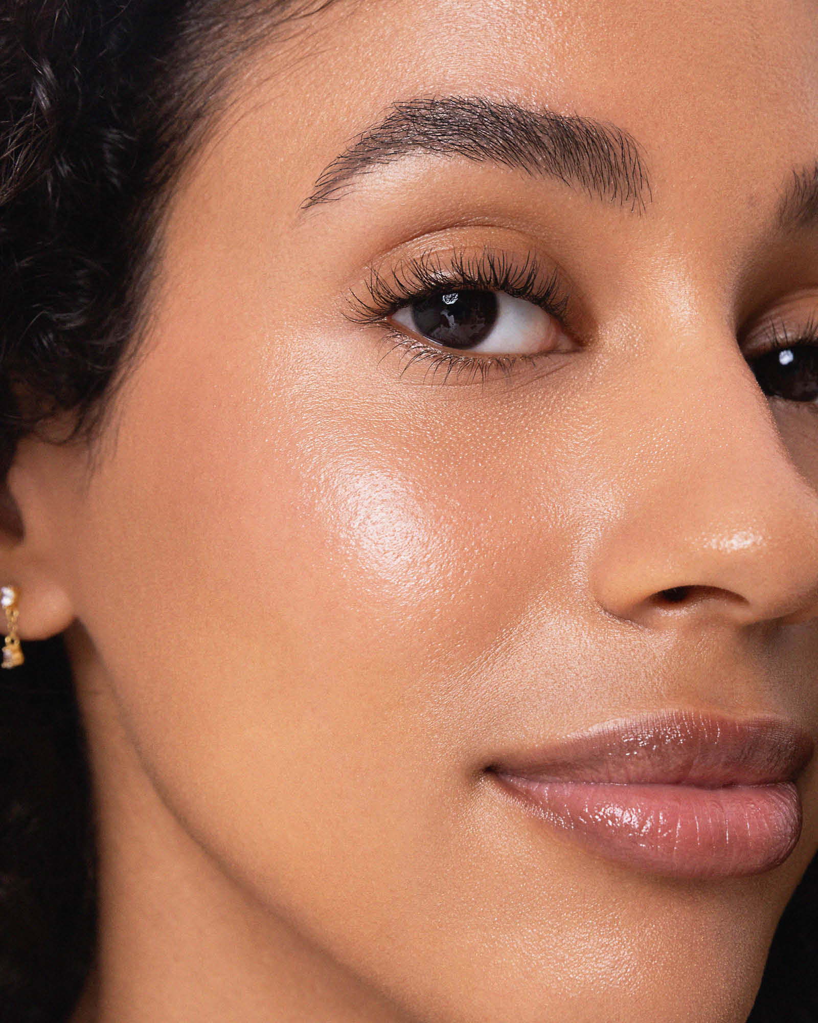 Model wearing Ere Perez Natural Almond Mascara for naturally defined lashes
