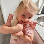 Smiling child holding Euclove Laundry Wash