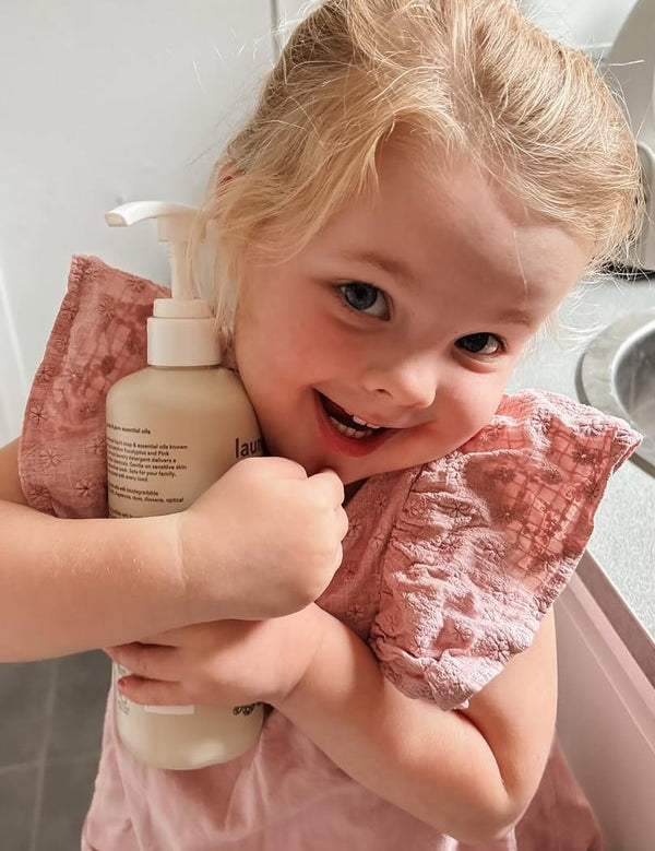 Smiling child holding Euclove Laundry Wash