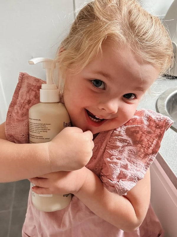 Smiling child holding Euclove Laundry Wash