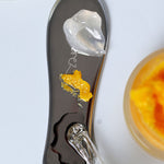 Ere Perez Steel Face Tool gua sha with dollops of skincare on its polished steel surface