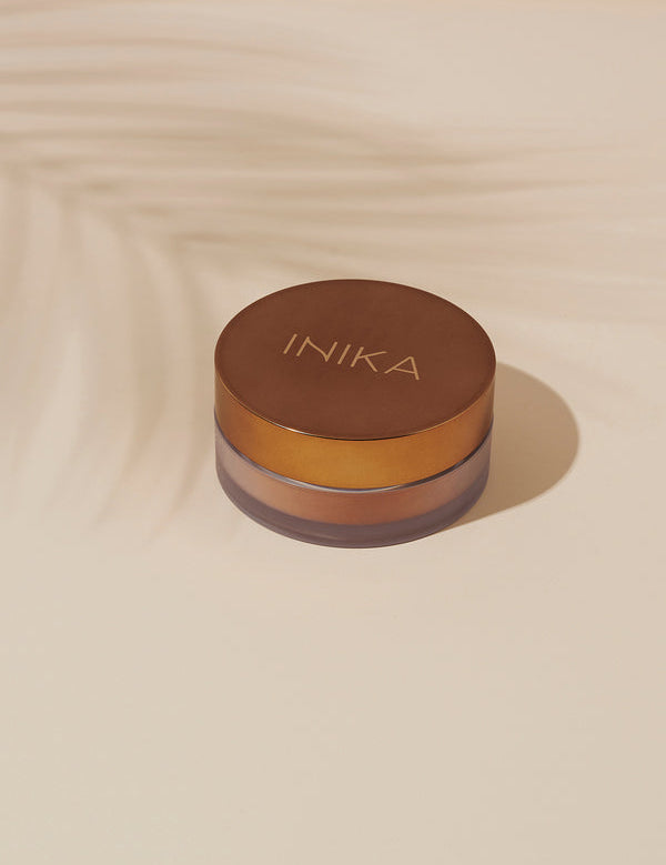 Model applying INIKA Organic Loose Mineral Bronzer in Sunkissed
