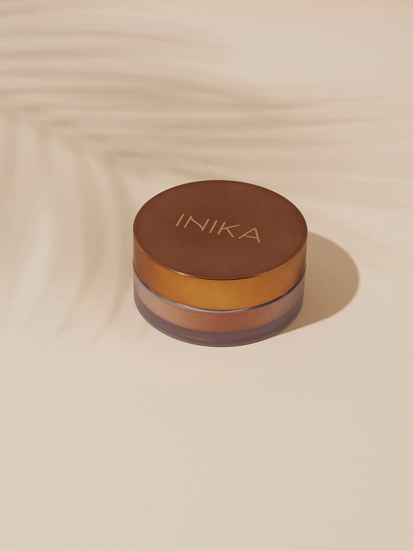 Model applying INIKA Organic Loose Mineral Bronzer in Sunkissed