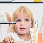 Child brushing teeth beside Davids Orange and Vanilla Toothpaste