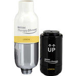 Waters Therapy Shower filter cartridge set in Lemon flavor, showing the white and silver top section of the shower head with the yellow lemon label, next to the black cylindrical replacement filter cartridge with white UP arrows.