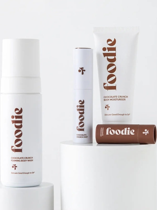 Vanessa Megan Foodie Chocolate Crunch four-piece Body Bundle: foaming body wash, body moisturiser, face and body mist, and lip balm arranged on white display plinths.