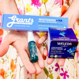 A person in a colorful floral dress holds the FREE Sample Box with Orders $149+—auto added to your order—for a touch of radiant self-care.