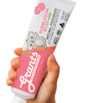 A hand holding a pink and white Grants Kids Bubblegum Bliss +HA 75g toothpaste tube with a koala illustration against a white background.