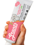 A hand holding a pink and white Grants Kids Bubblegum Bliss +HA 75g toothpaste tube with a koala illustration against a white background.