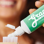 Grants Mild Mint toothpaste applied to a bamboo toothbrush